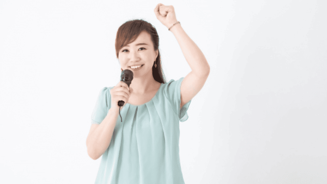 マイクを持って歌う女性