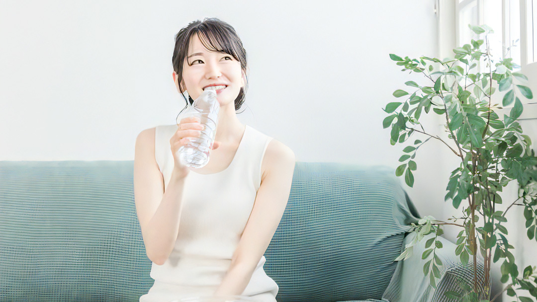 ペットボトルの水を飲む女性