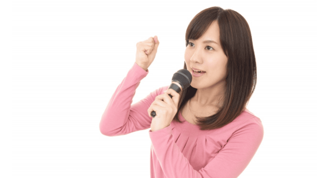 ガッツポーズで歌う女性