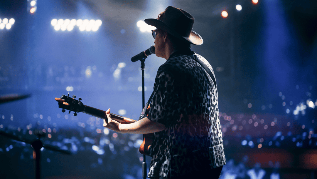 ギターを弾きながら歌う男性