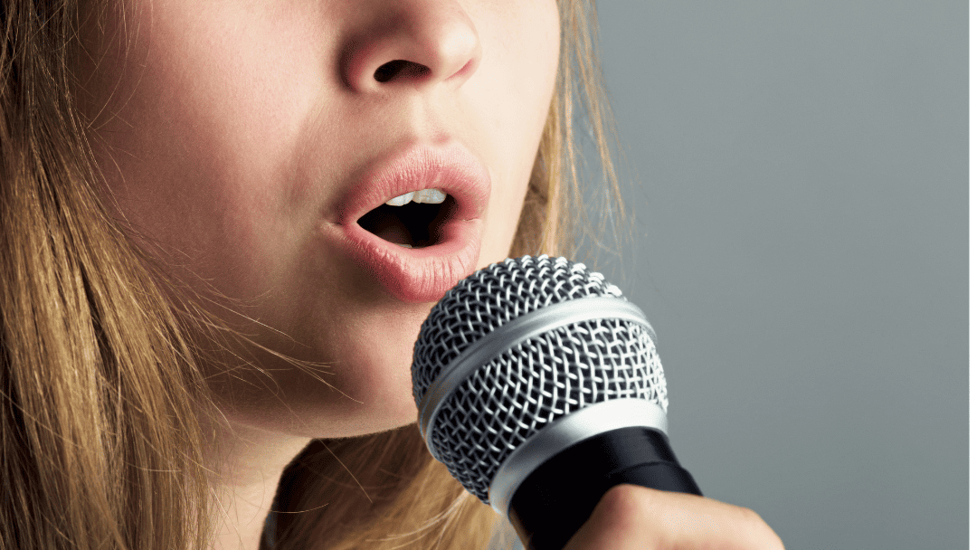 マイクを持って歌う女性の口元