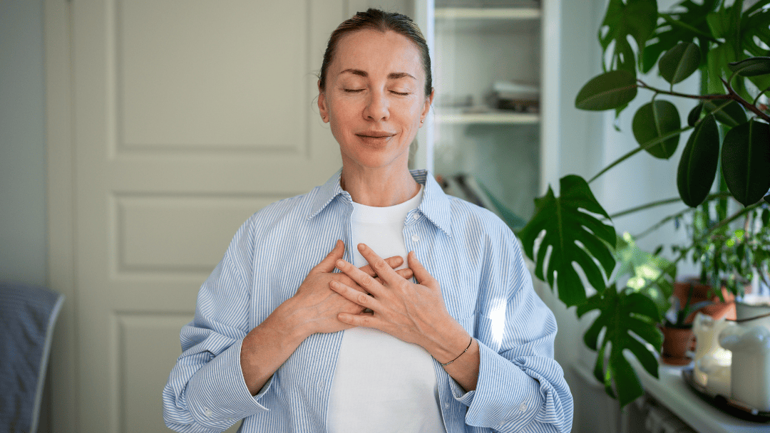 胸を抑えている女性