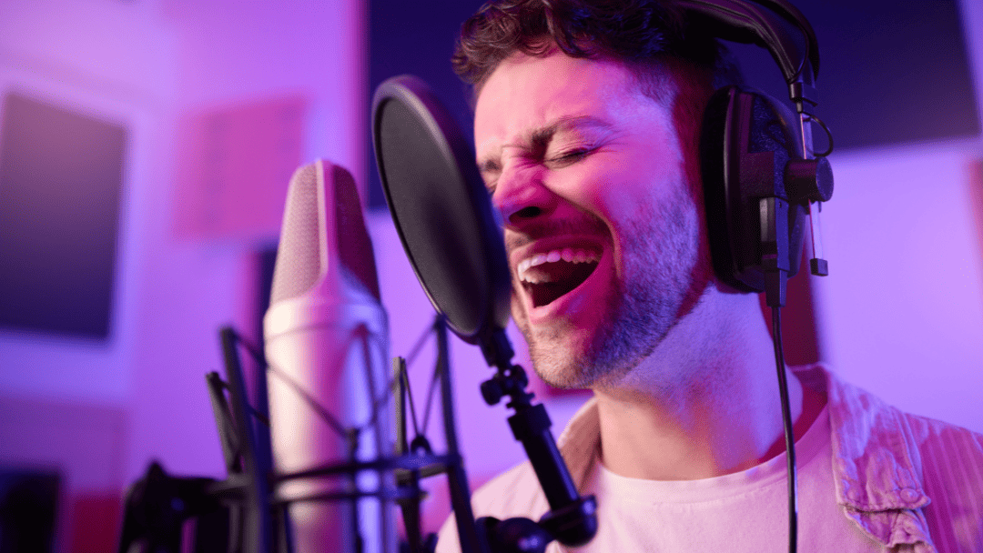 ヘッドフォンをしてマイクの前で歌う男性