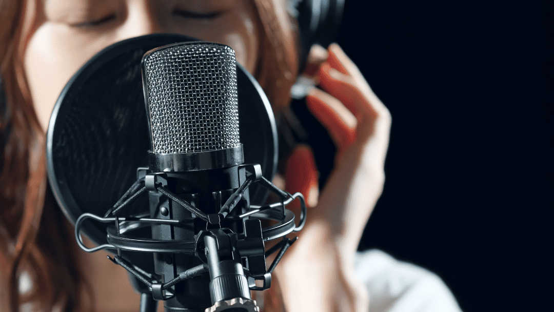 マイクを前にヘッドフォンをして歌おうとする女性