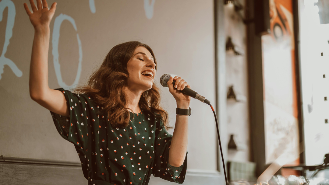 マイクを持って歌う女性