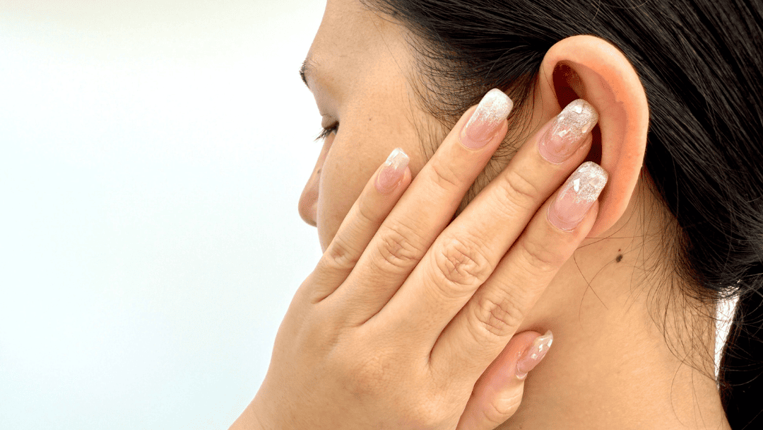 耳を抑える女性