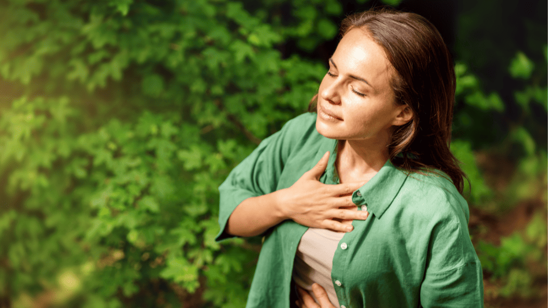 胸に手を置いて深呼吸する女性