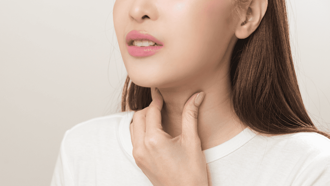 喉を抑える女性