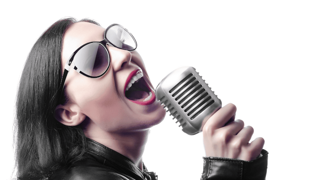 マイクを持って歌い上げる、サングラスをした女性