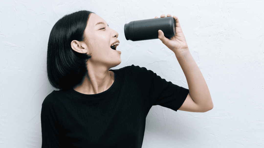 水筒をマイク代わりに歌う女性