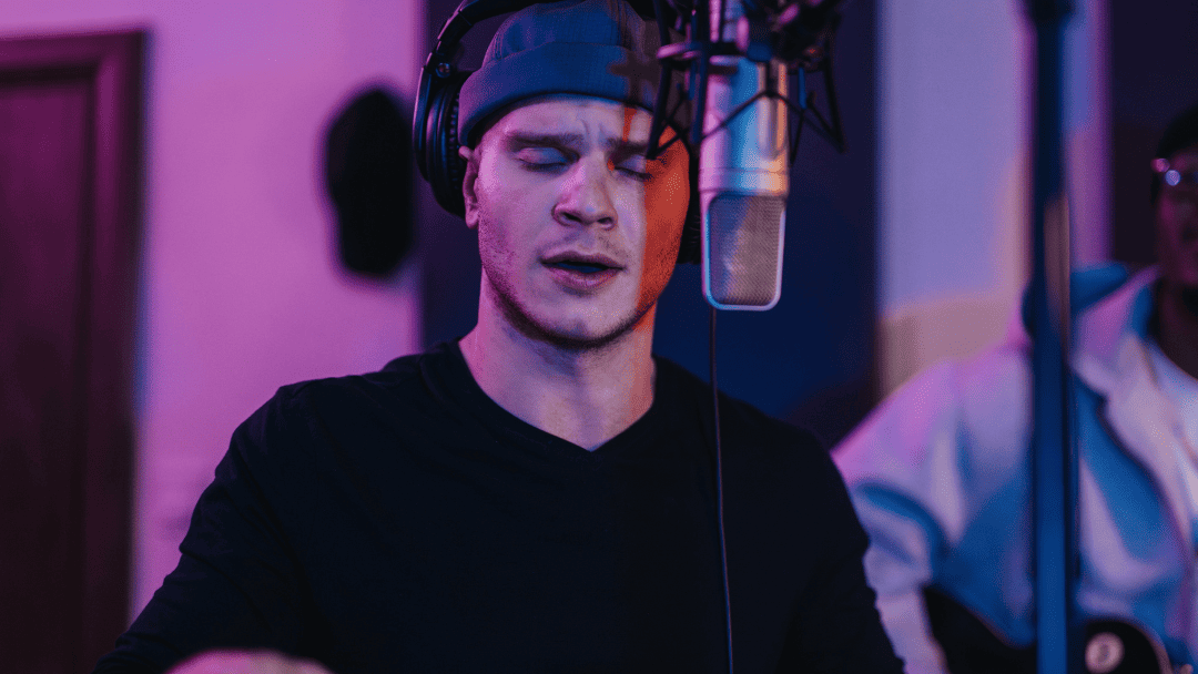 コンデンサーマイクの前で歌う男性