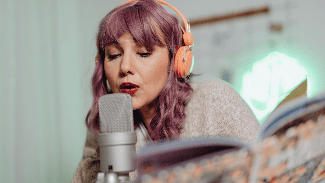 ヘッドフォンをしてマイクの前で歌う女性