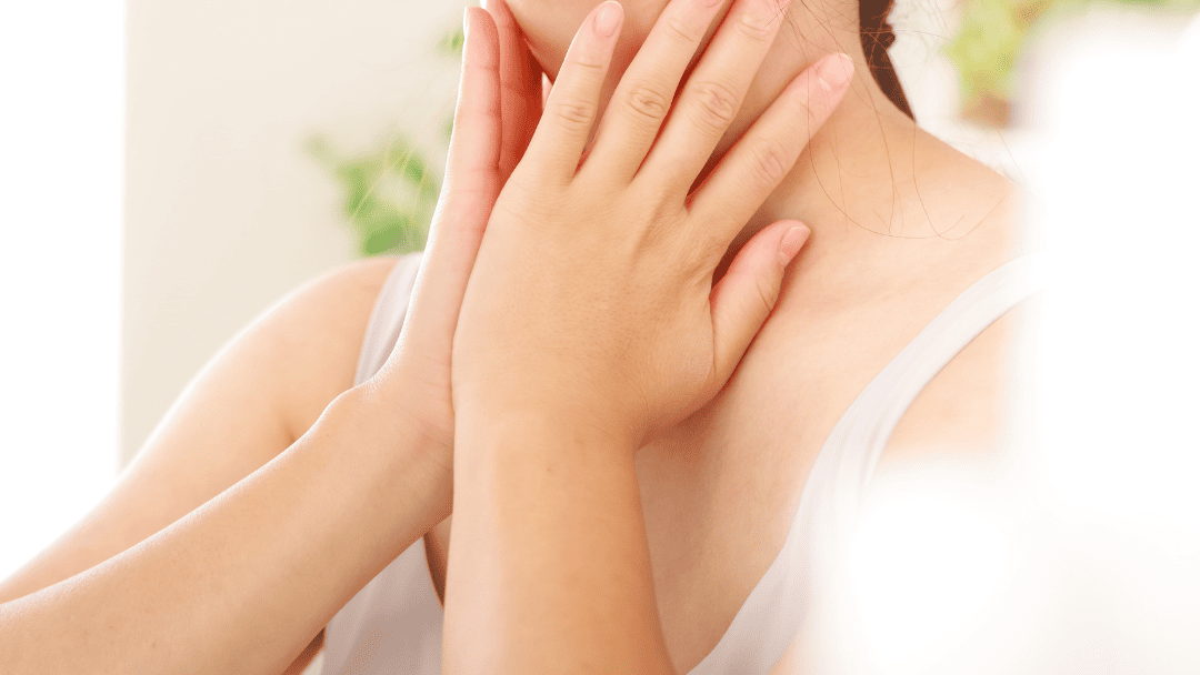 喉を両手で触っている人