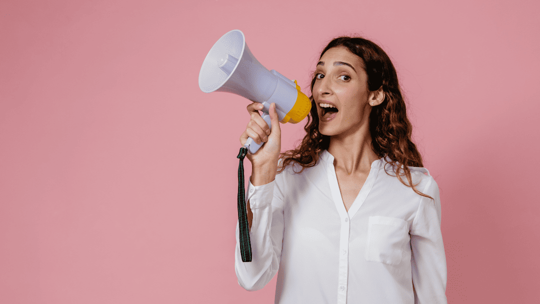 拡声器を持って声を出す女性