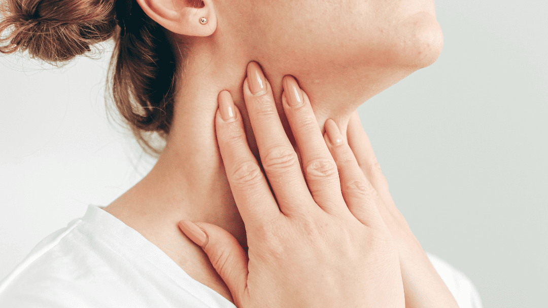 喉を押さえる女性