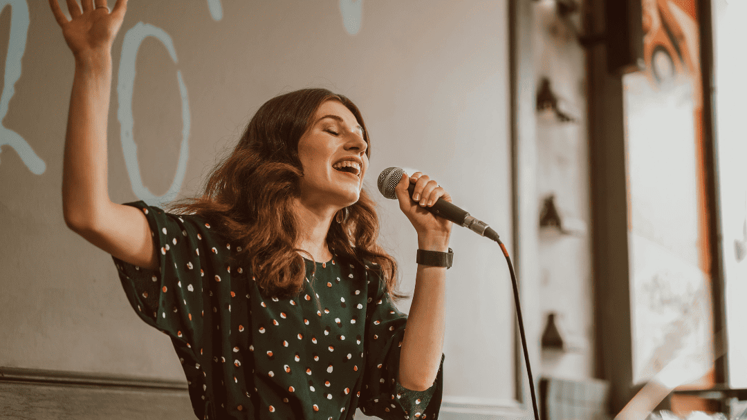 マイクを持って熱唱する女性