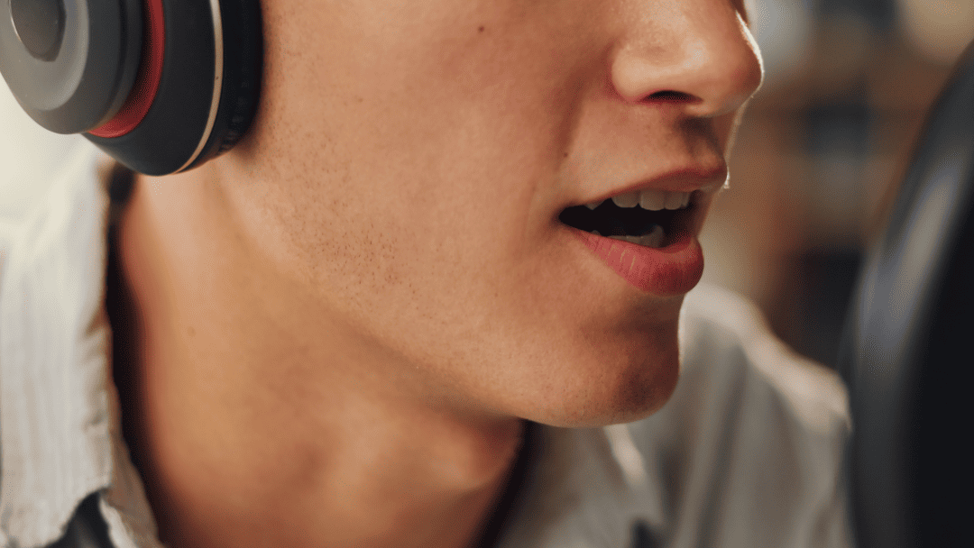 ヘッドフォンをして声を出す男性