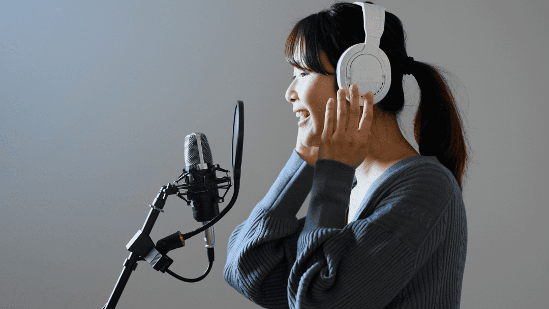 ヘッドフォンをしてマイクに向けて声を出す女性