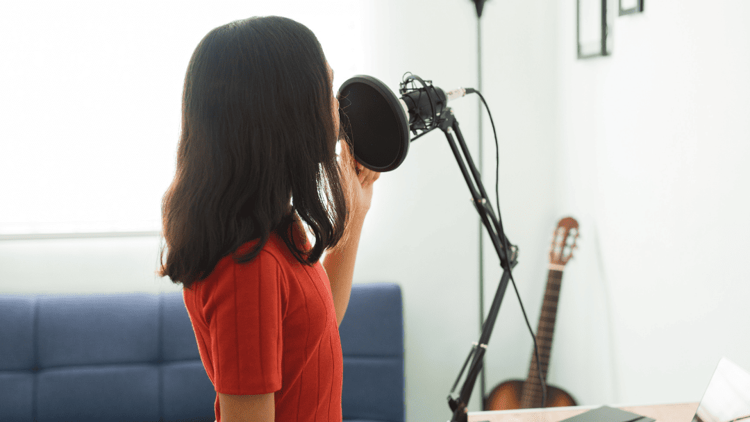 コンデンサーマイクの前で歌う女性