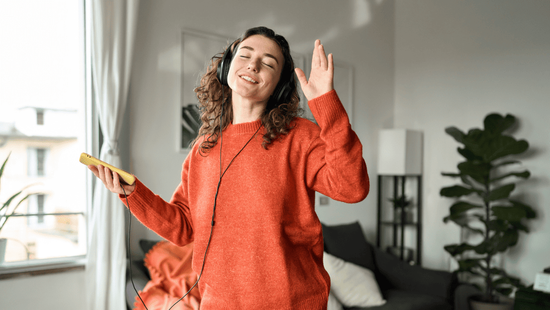 ヘッドフォンをして自宅で歌う女性