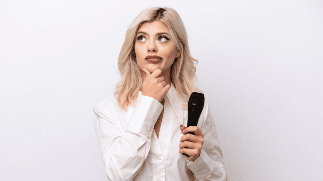 マイクを持って考えている女性