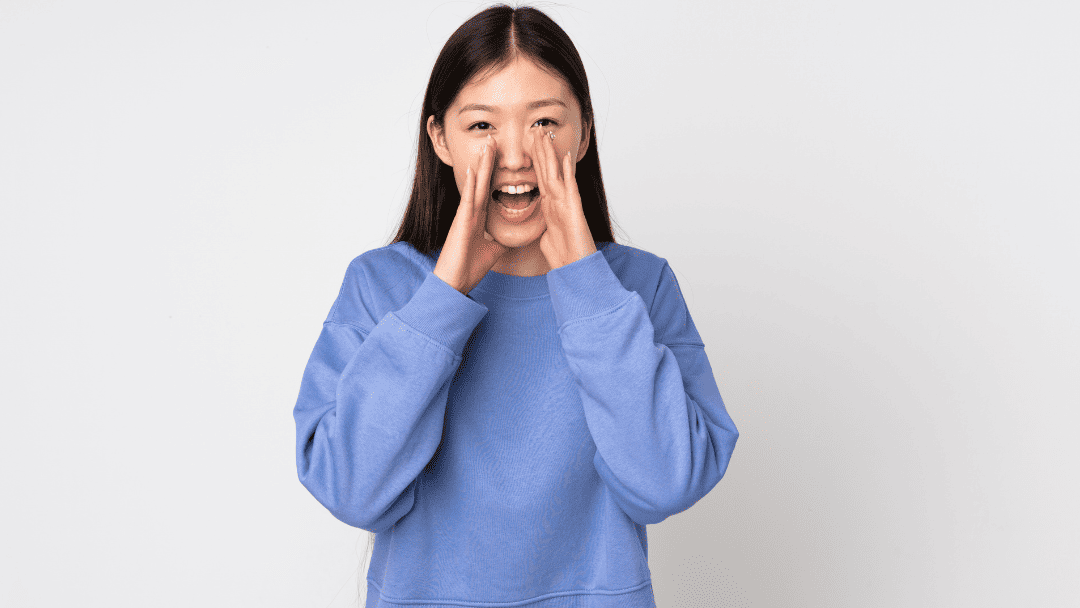 手を口に沿えて叫ぶ女性