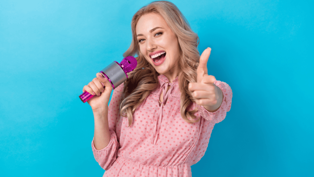 マイクを持って指を指す女性