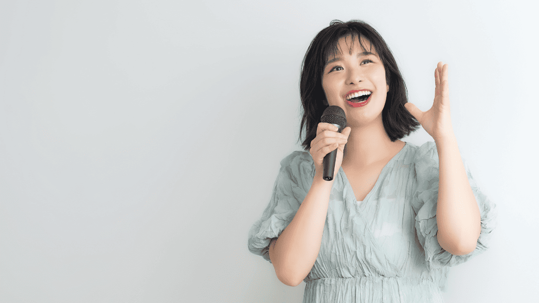 マイクを持って歌う女性