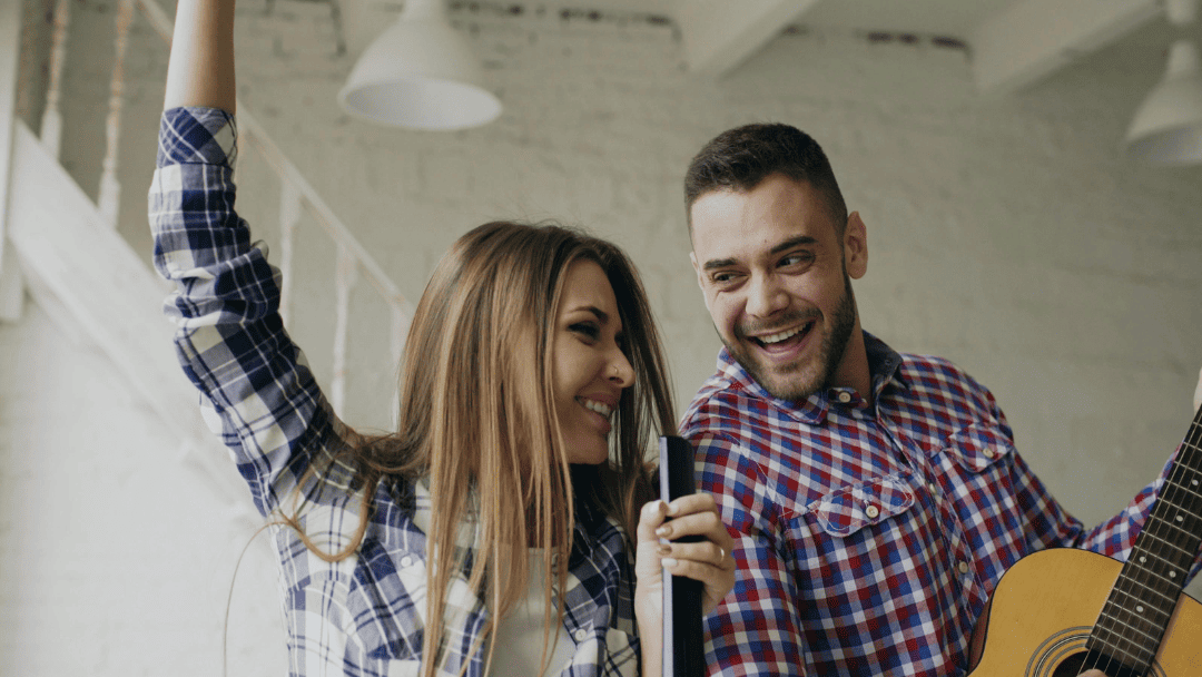 マイクで歌う女性とギターを弾く男性