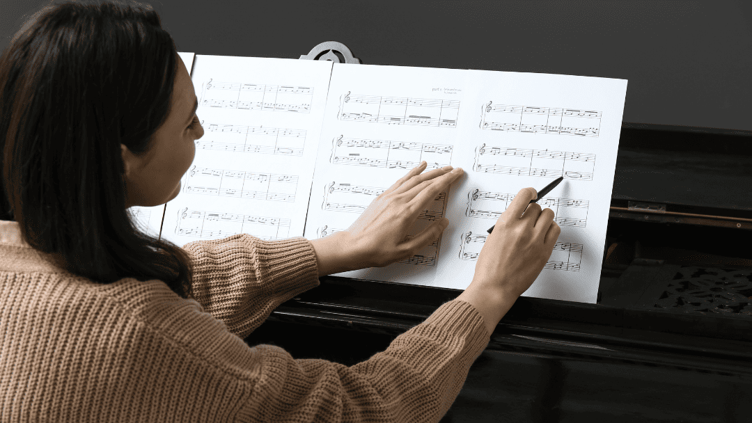 ピアノの楽譜に書き込む女性